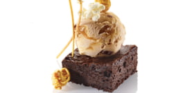 BROWNIE CHUNKS A CARAMEL VANILLA ICE CREAM, DARK CHOCOLATE BROWNIE, POPCORN, CARAMEL AND GOLDEN SHORT CUT PASTRY STICKS