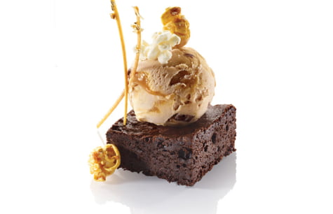 BROWNIE CHUNKS A CARAMEL VANILLA ICE CREAM, DARK CHOCOLATE BROWNIE, POPCORN, CARAMEL AND G...