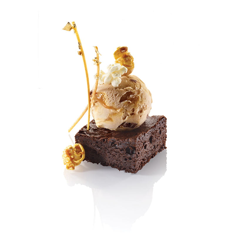 Glace vanille caramel brownie sur socle de brownie, agrémentée de pop corn nature et caramel et baguette de pâte brisé dorée